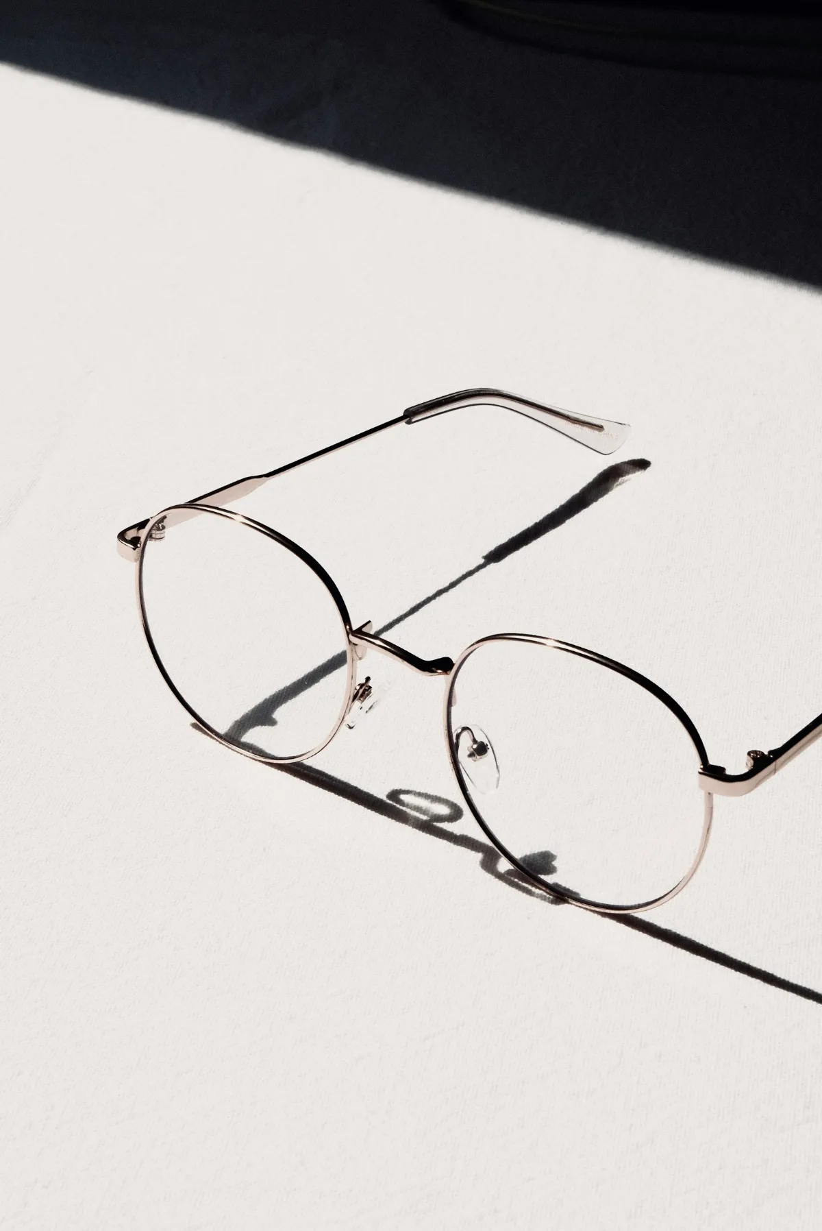 Slim silver-framed spectacles on a pale surface